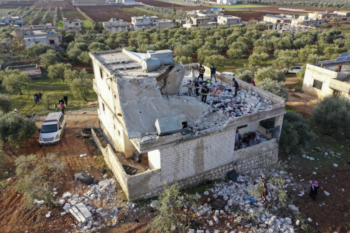 People inspect a destroyed house following an operation by the U.S. military in the Syrian village of Atmeh, in Idlib province, Syria, Thursday, Feb. 3, 2022. U.S. special operations forces conducted a large-scale counterterrorism raid in northwestern Syria overnight Thursday, in what the Pentagon said was a "successful mission." Residents and activists reported multiple deaths including civilians from the attack.