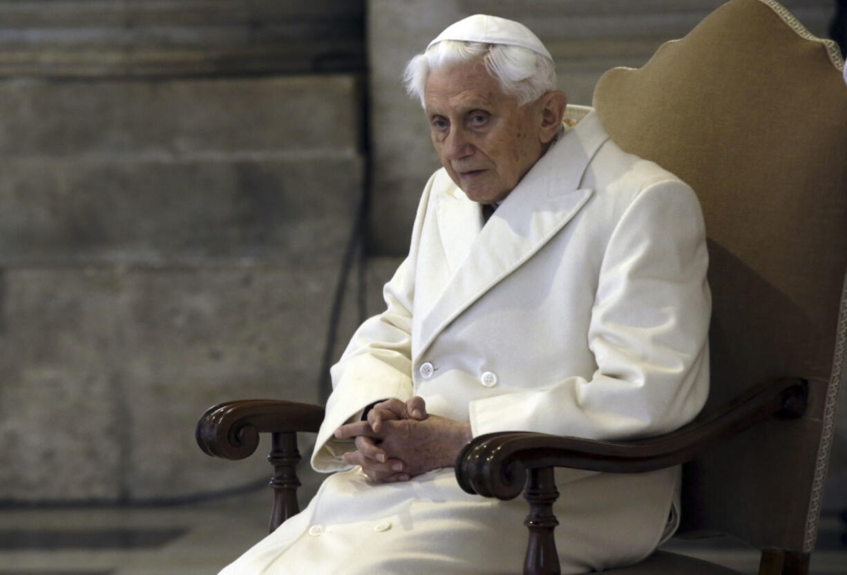 FILE - This Dec. 8, 2015 file photo shows Pope Emeritus Benedict XVI sitting in St. Peter's Basilica as he attends the ceremony marking the start of the Holy Year. Retired Pope Benedict XVI asked forgiveness Tuesday, Feb. 8, 2022,  for any "grievous faults" in his handling of clergy sex abuse cases, but admitted to no personal or specific wrongdoing after an independent report criticized his actions in four cases while he was archbishop of Munich, Germany.