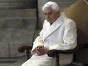 FILE - This Dec. 8, 2015 file photo shows Pope Emeritus Benedict XVI sitting in St. Peter's Basilica as he attends the ceremony marking the start of the Holy Year. Retired Pope Benedict XVI asked forgiveness Tuesday, Feb. 8, 2022,  for any "grievous faults" in his handling of clergy sex abuse cases, but admitted to no personal or specific wrongdoing after an independent report criticized his actions in four cases while he was archbishop of Munich, Germany.