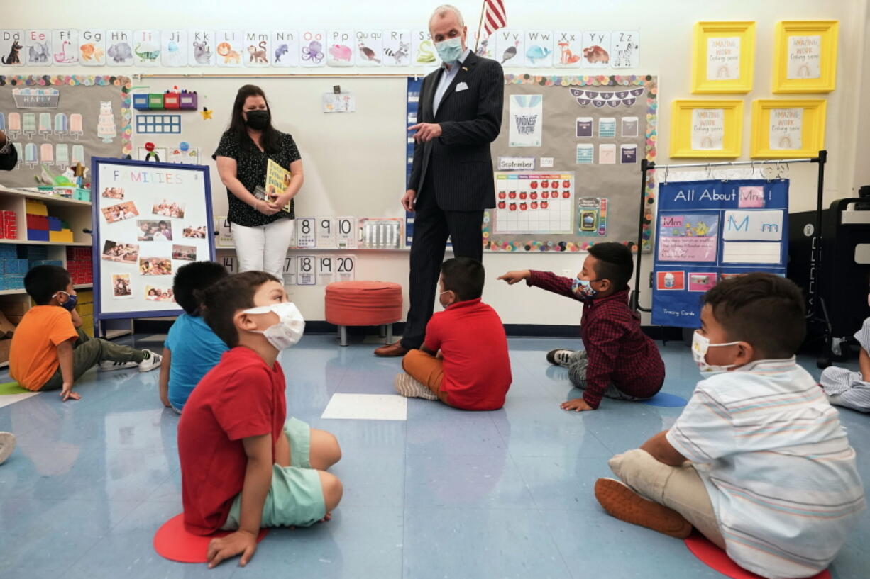 FILE -- New Jersey Gov. Phil Murphy talks to three and four year old students in a pre-K class at the Dr. Charles Smith Early Childhood Center, Sept. 16, 2021, in Palisades Park, N.J. Murphy will end a statewide mask mandate to protect against COVID-19 in schools and child care centers, his office said Monday, Feb 7, 2022.