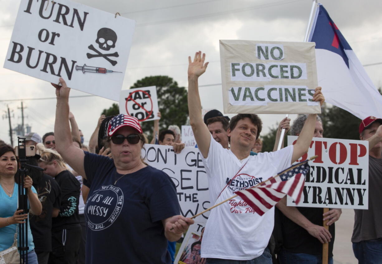 FILE - In this June 7, 2021, photo, demonstrators at Houston Methodist Baytown Hospital in Baytown, Texas, wave at cars that honk at them to support their protest against a policy that says hospital employees must get vaccinated against COVID-19 or lose their jobs. Religious exemptions are increasingly becoming a workaround for hospital and nursing home staff who want to keep their jobs in the face of federal COVID-19 vaccine mandates that are going into effect nationwide this week.