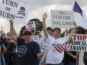 FILE - In this June 7, 2021, photo, demonstrators at Houston Methodist Baytown Hospital in Baytown, Texas, wave at cars that honk at them to support their protest against a policy that says hospital employees must get vaccinated against COVID-19 or lose their jobs. Religious exemptions are increasingly becoming a workaround for hospital and nursing home staff who want to keep their jobs in the face of federal COVID-19 vaccine mandates that are going into effect nationwide this week.