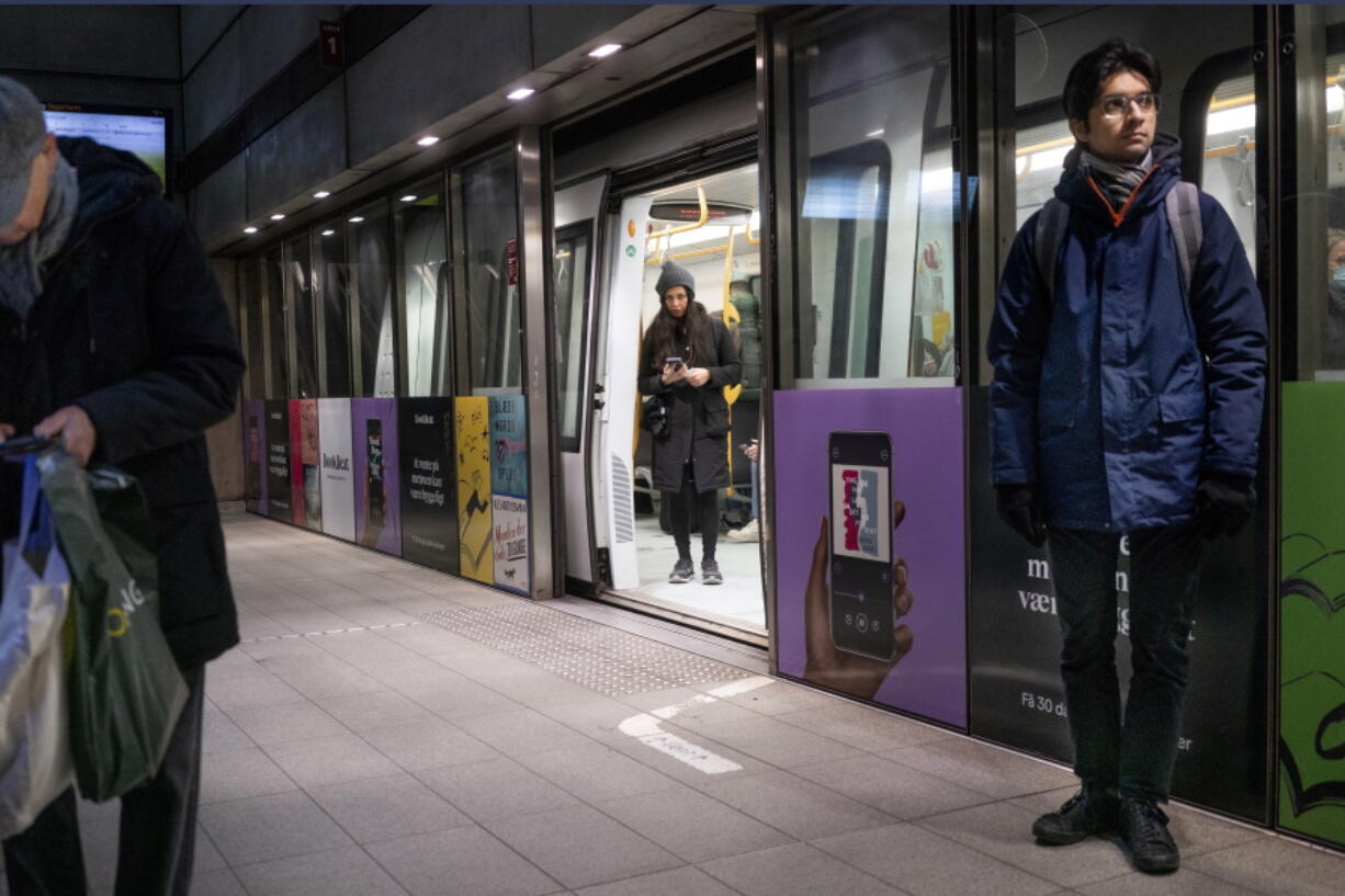 FILE - Passengers stand at the Noerreport Metrostation in Copenhagen Denmark, Tuesday, Feb. 1, 2022. Denmark has become one of the first European Union countries to scrap most pandemic restrictions as the country no longer considers the COVID-19 outbreak "a socially critical disease." Bit by bit, many countries that have been especially hard-hit by the coronavirus are easing their tough, and often unpopular, restrictive measures to fight COVID-19 even as the omicron variant -- deemed less severe -- has caused cases to skyrocket.