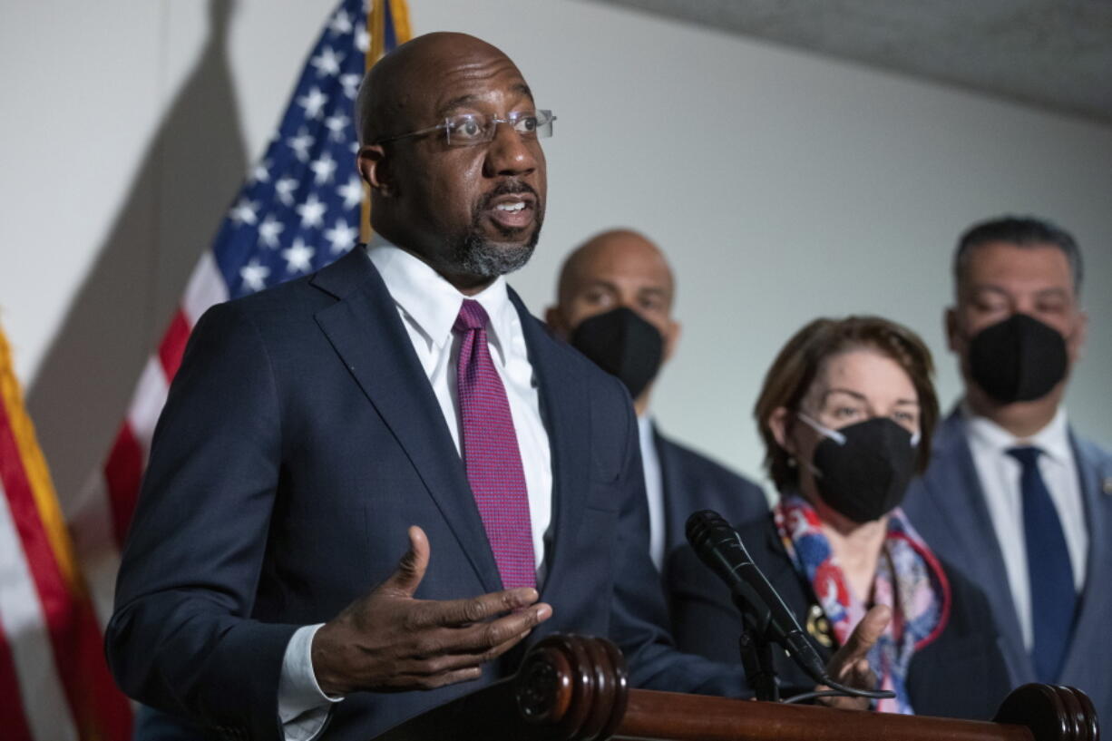 FILE - Sen. Raphael Warnock, D-Ga., speaks to reporters alongside Sen. Cory Booker, D-N.J., and Sen. Amy Klobuchar, D-Minn., and Sen. Alex Padilla, D-Calif., during a news conference at the Capitol in Washington, on Jan. 18, 2022.