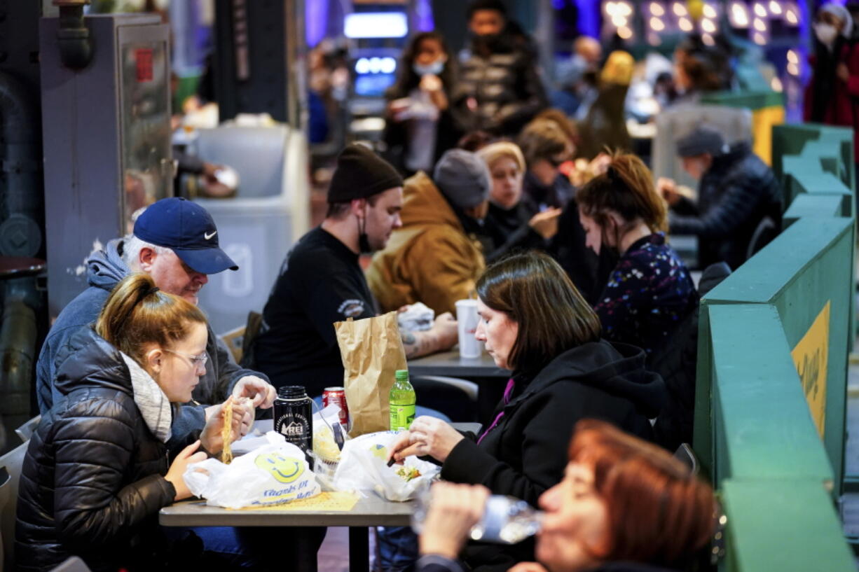 Customers eat at the Reading Terminal Market in Philadelphia, Wednesday, Feb. 16, 2022.  Philadelphia city officials lifted the city's vaccine mandate for indoor dining and other establishments that serve food and drinks, but an indoor mask mandate remains in place. Philadelphia Public Health officials announced that the vaccine mandate was lifted immediately Wednesday.