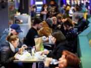 Customers eat at the Reading Terminal Market in Philadelphia, Wednesday, Feb. 16, 2022.  Philadelphia city officials lifted the city's vaccine mandate for indoor dining and other establishments that serve food and drinks, but an indoor mask mandate remains in place. Philadelphia Public Health officials announced that the vaccine mandate was lifted immediately Wednesday.