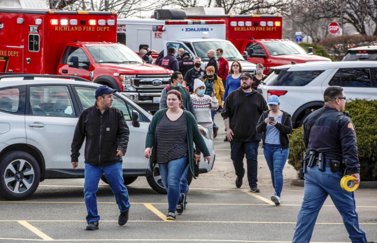 Customers and employees are guided out of a Fred Meyer grocery store after a fatal shooting at the business on Wellsian Way in Richland, Wash., Monday, Feb. 7, 2022.