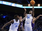 UCLA guard David Singleton (34) scores against Washington during the second half of an NCAA college basketball game Saturday, Feb. 19, 2022, in Los Angeles.