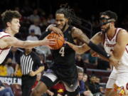 Washington guard PJ Fuller, center, drives between Southern California guard Drew Peterson, left, and forward Isaiah Mobley during the first half of an NCAA college basketball game in Los Angeles, Thursday, Feb. 17, 2022.