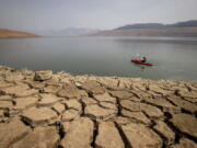 FILE - A kayaker paddles in Lake Oroville as water levels remain low due to continuing drought conditions in Oroville, Calif., on Aug. 22, 2021. The American West's megadrought deepened so much last year that it is now the driest it has been in at least 1200 years and a worst-case scenario playing out live, a new study finds.