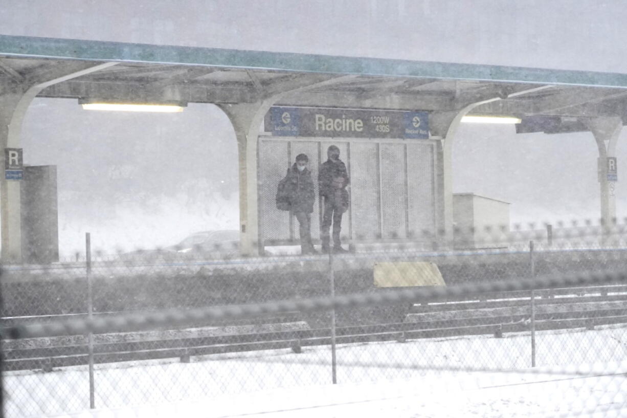 Commuters wait for a Blue Line train as a winter storm descends upon Chicago, Thursday, Feb. 17, 2022. Illinois State Police urged motorists to stay off roads Thursday after as much as 4 inches of wind-blown snow led to whiteout conditions and multiple pileups. The Illinois Department of Transportation closed Interstate 39 north of Bloomington after police said a pileup several hundred yards long involved approximately 100 vehicles.