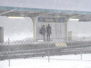 Commuters wait for a Blue Line train as a winter storm descends upon Chicago, Thursday, Feb. 17, 2022. Illinois State Police urged motorists to stay off roads Thursday after as much as 4 inches of wind-blown snow led to whiteout conditions and multiple pileups. The Illinois Department of Transportation closed Interstate 39 north of Bloomington after police said a pileup several hundred yards long involved approximately 100 vehicles.