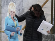 Rep. Monica Stonier, D-Vancouver, holds a photo cut-out of singer Dolly Parton as she walks to the floor of the House on Jan. 26 at the Capitol in Olympia. Stonier co-sponsored a measure that establishes statewide Parton's Imagination Library, which gives children age 5 and under free books each month. (Ted S.