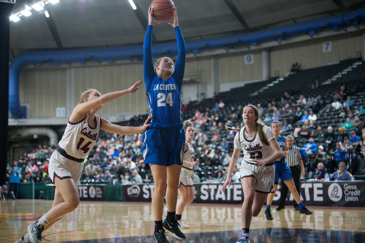 La Center's Kylee Stephens, center, reaches out to secure a lob pass into the post between Colville defenders Kaelyn Malone, left, and Mckenna Reggear, right, during a Class 1A loser-out state game Wednesday at the Yakima Valley SunDome.