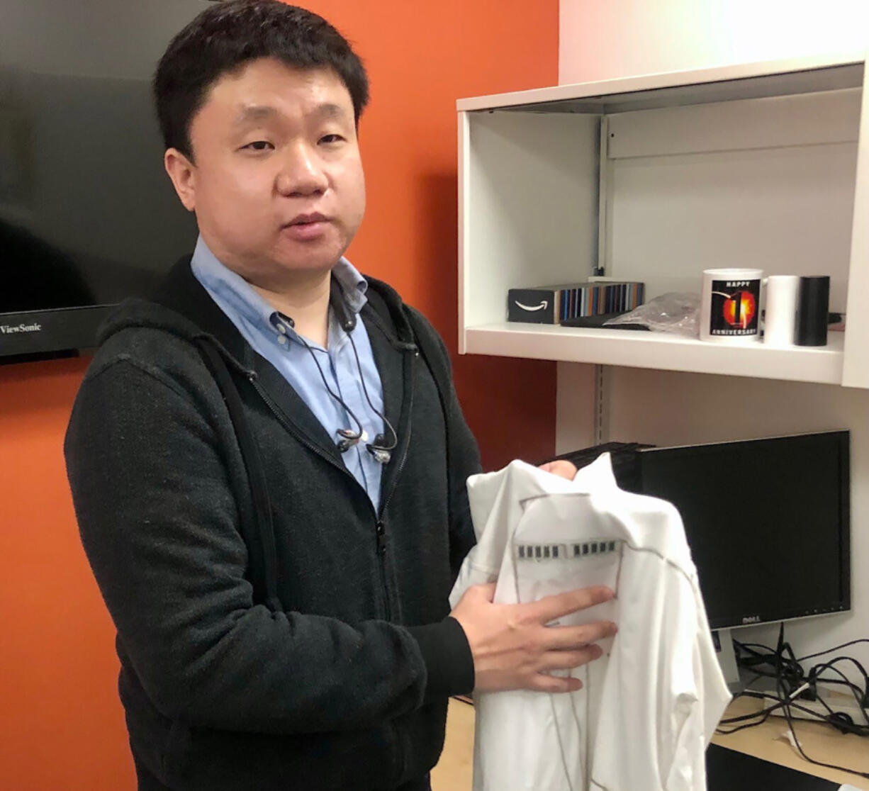 Yu Lin, a UC San Diego Ph. D. student at the Jacobs School of Engineering, holds what researches have dubbed a "wearable microgrid" that can harvest and store energy while the wearer moves or exercises.