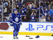 Toronto Maple Leafs forward Auston Matthews (34) celebrates his hat trick as fans throw their hats on the ice while during the third period of an NHL hockey game against the Seattle Kraken, Tuesday, March 8, 2022, in Toronto.