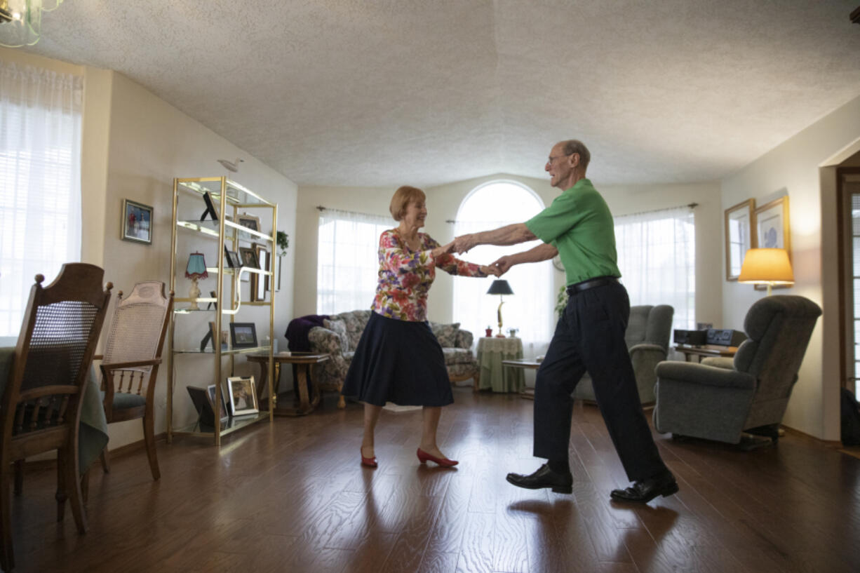 Jim Ferris, 82, and Thea Sturm, 89, dance in their Hazel Dell living room on Saturday. The pair met at a dance class at the Luepke Community Center three years ago and have danced together since then.