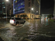 A car drives through a flooded Northeast 11th Street and Biscayne Boulevard in downtown Miami on Feb. 16, 2021.