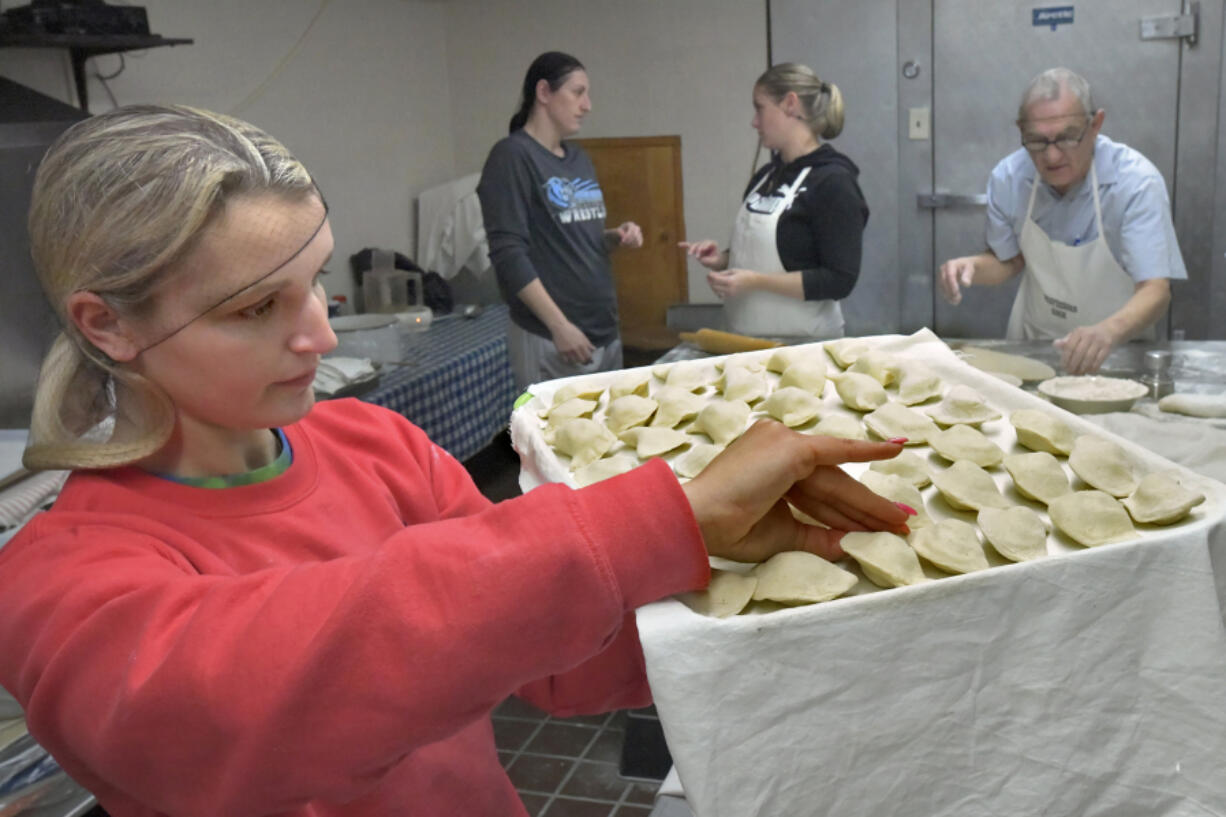 Melanya Humeniuk checks the pierogies to make sure they are tightly pinched together before they are boiled. Volunteers at St. Michael The Archangel Ukrainian Catholic Church in Baltimore have been busy all week making Ukrainian specialties, including potato and sauerkraut pierogi. All the profits will be donated to help Ukrainians at war with Russia.