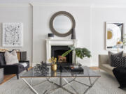 An oversized round mirror helps to anchor the fireplace in this space.