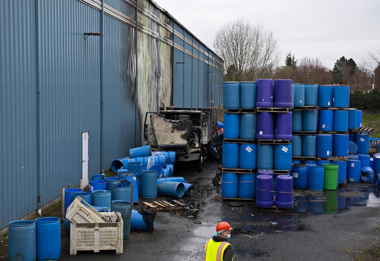 A worker looks over the scene after more than 40 firefighters battled a two-alarm fire at Northwest Packing Co. at the Port of Vancouver on Tuesday morning, March 29, 2022.