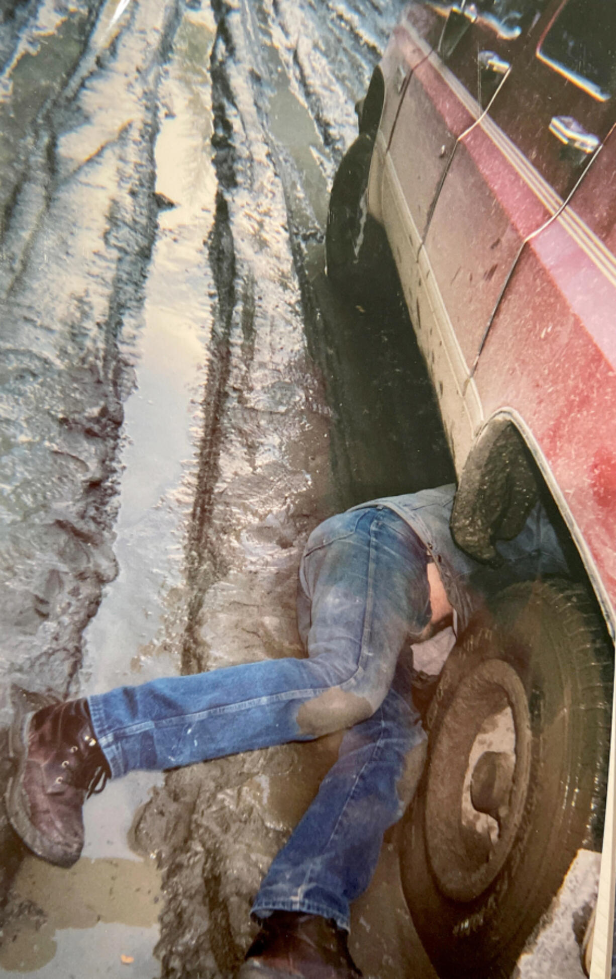 Cowboy Joey fixes the muffler during spring thaw in Alaska -- while his Alaskan woman takes the photo.