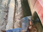 Cowboy Joey fixes the muffler during spring thaw in Alaska -- while his Alaskan woman takes the photo.