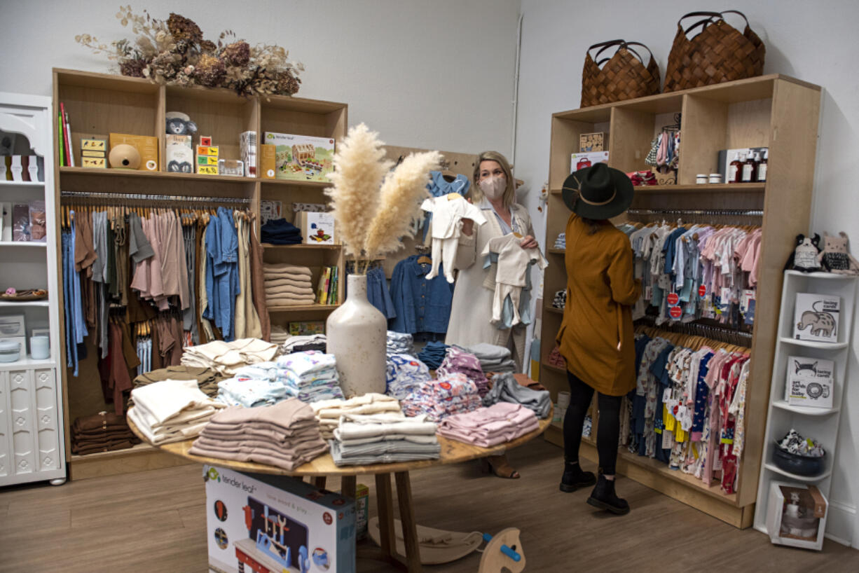 Melanie Wyckoff, left, owner of Lyon & Pearle, looks over items for babies with her daughter-in-law, Jessica Wyckoff, in downtown Vancouver. "I love, love children and I love women," Melanie Wyckoff said.