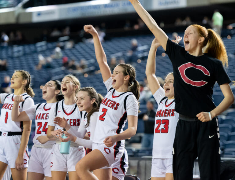 The Camas bench celebrates a made 3-pointer in a 4A State Girls Basketball consolation game on Friday, March 4, 2022, at the Tacoma Dome.