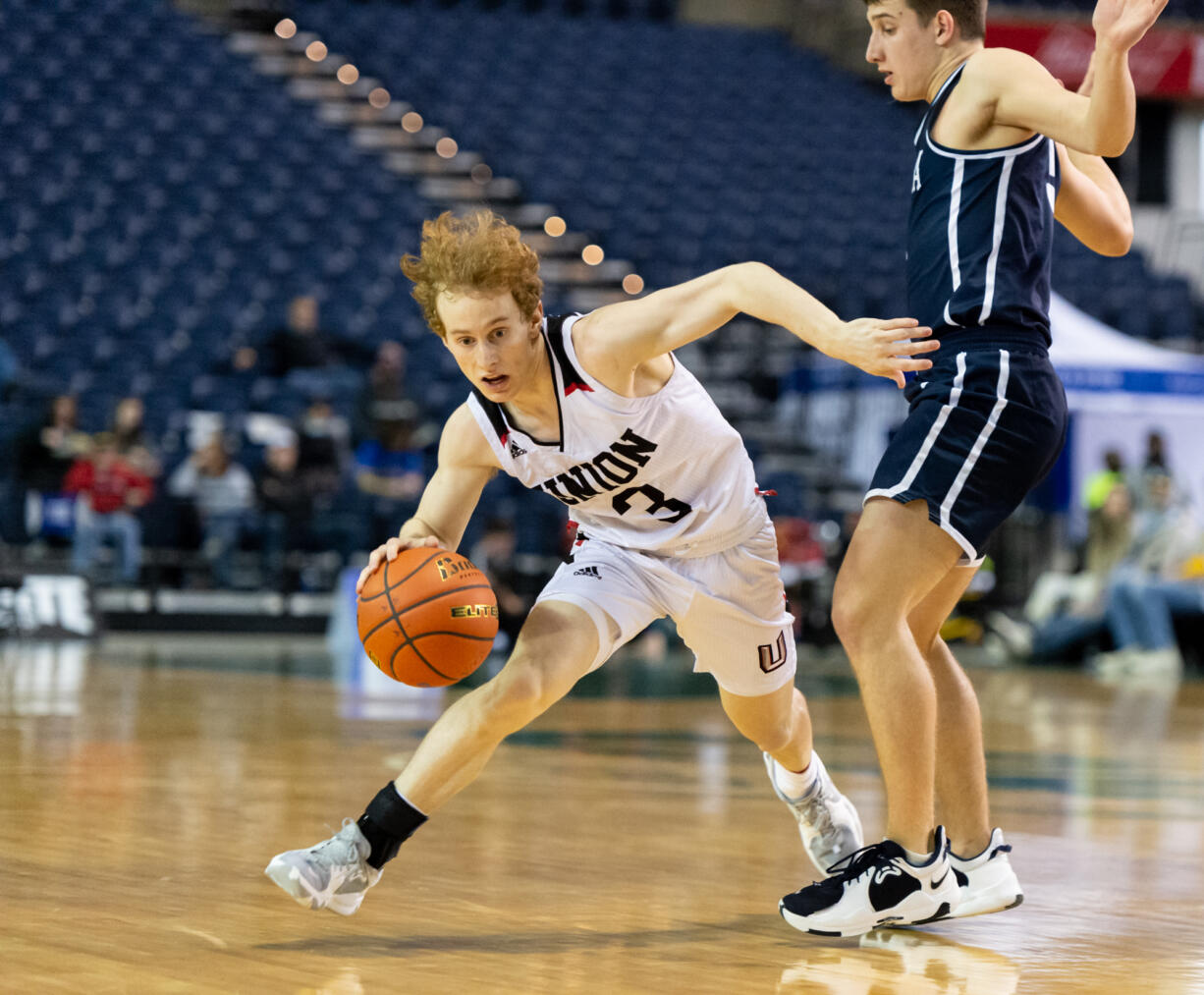 Union's Bryson Metz gets knocked off balance by Olympia's Mason Juergens on his way to the basket in a 4A State Boys Basketball third-place game on  Saturday, March 5, 2022, at the Tacoma Dome.