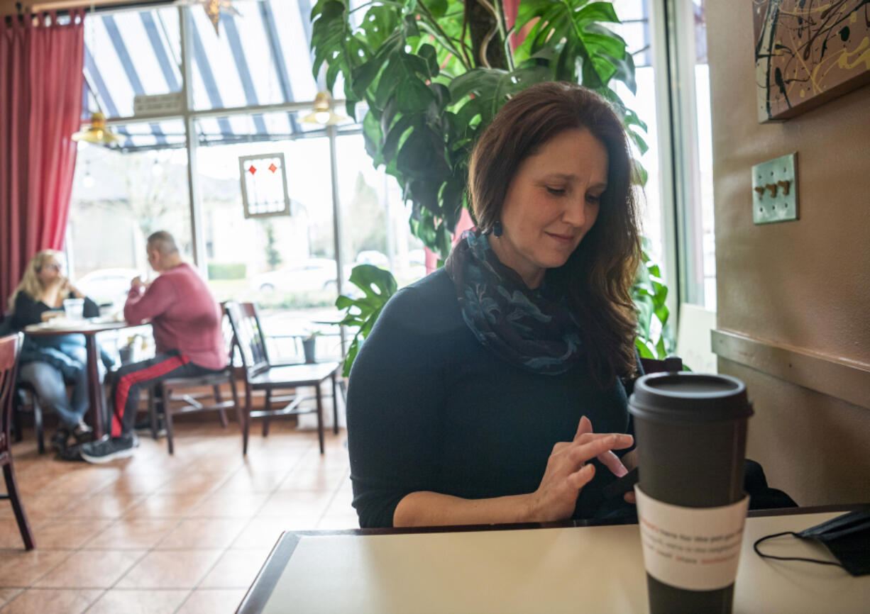 Driver Jennifer Heinlein of Vancouver waits for a call for a ride Friday at Savona Coffee House. She enjoys the flexibility of being a contract ride-hail driver, but also wants to receive sick leave and other employee benefits.