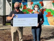 Camas Lions Club President Brian Scott presents Washougal Community Library Branch Manager Rachael Ries with a $1,001 check to help fund the new library building.