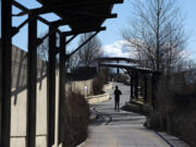 A runner jogs in the sunshine on the renovated Confluence Land Bridge on Wednesday morning. Crews have recently replaced the bridge's eroded granite footpath with more resilient pavers.