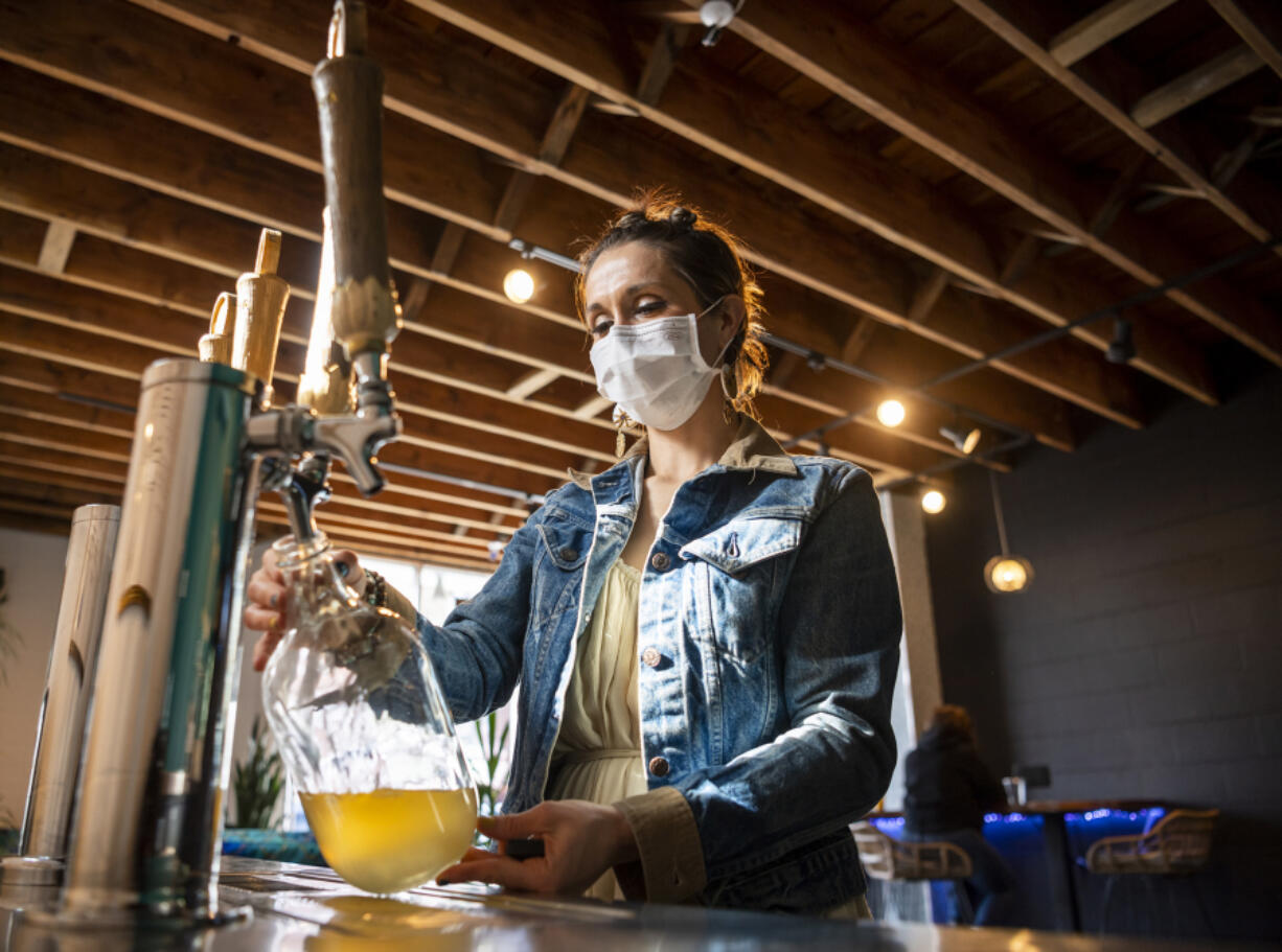 SOMA Kombucha Taproom Manager Savannah Lowe fills a growler with kombucha. The self-serve taproom is open 24 hours a day.