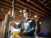 SOMA Kombucha Taproom Manager Savannah Lowe fills a growler with kombucha. The self-serve taproom is open 24 hours a day.