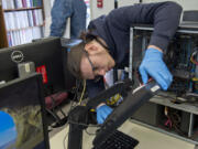 Senior Ethan Zanoli, the marketing manager for Cascadia Technical Academy's Information Technology Program, tests a monitor that was donated Saturday during the program's annual Electronic Waste Recycling Event. At top are harvested computer parts that were dropped off Saturday. This year marks the event's 10th anniversary.