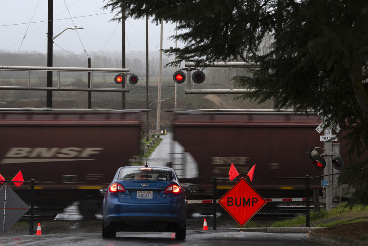 A motorist stops at the Division Street railroad crossing in Ridgefield as a construction sign is seen near the tracks.