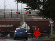 A motorist stops at the Division Street railroad crossing in Ridgefield as a construction sign is seen near the tracks.