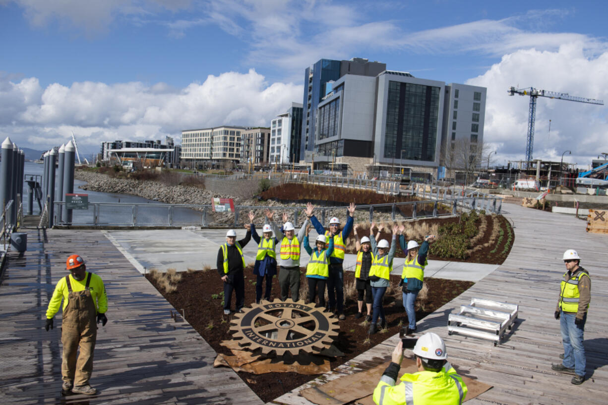 Members of the Vancouver Rotary Club and the Vancouver Rotary Foundation join representatives from the Port of Vancouver as they celebrate the installation of a new bronze Rotary symbol along Rotary Way at the port's Terminal 1 development at the Vancouver waterfront on Tuesday afternoon.