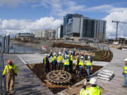 Members of the Vancouver Rotary Club and the Vancouver Rotary Foundation join representatives from the Port of Vancouver as they celebrate the installation of a new bronze Rotary symbol along Rotary Way at the port's Terminal 1 development at the Vancouver waterfront on Tuesday afternoon.