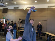 Fifth-grader D.J. Wilkins, left, and sixth-grader Urijah Fischer, get a chance to experience a toy drone during a presentation from Skanska, an international development and construction company, at the Washington School for the Deaf on Monday morning. The school is beginning the initial stages of its expansion and using it as an opportunity for students to engage with a new form of technology to help in the project.