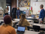 Columbia River English and history teacher Natasha Flak, from left, history teacher Dave Douglas and paraeducator Ewa Teipel talk to world history teacher Tim Smith and his class Wednesday at Columbia River High School. In addition to leading the fundraising effort for refugees in Poland, the group has worked to teach students about fielding breaking news of the conflict and identifying forms of misinformation.