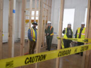 Lance Thielen of Pacific Tech Construction, left, joins National Park Service archaeologist Doug Wilson, Fort Vancouver National Site Superintendent Tracy Fortmann and National Park Service Director Chuck Sams during a tour of Building 993 on Wednesday.