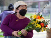 Florist Kia Lor, of C&K's Flower Garden, arranges fresh spring bouquets Saturday at the Vancouver Farmers Market.