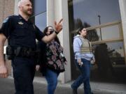 Longview Police Capt. Branden McNew, left, Columbia Wellness Chief Clinical Officer Kathy Ryan and Longview Police Behavioral Health Unit member River Phillips walk down Hudson Street Friday in front of the Longview Police Department headquarters.