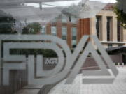 The U.S. Food and Drug Administration building is behind FDA logos at a bus stop on the agency's campus in Silver Spring, Md. The Food and Drug Administration has issued a negative review of a closely watched experimental drug for the debilitating illness known as Lou Gehrig's disease.