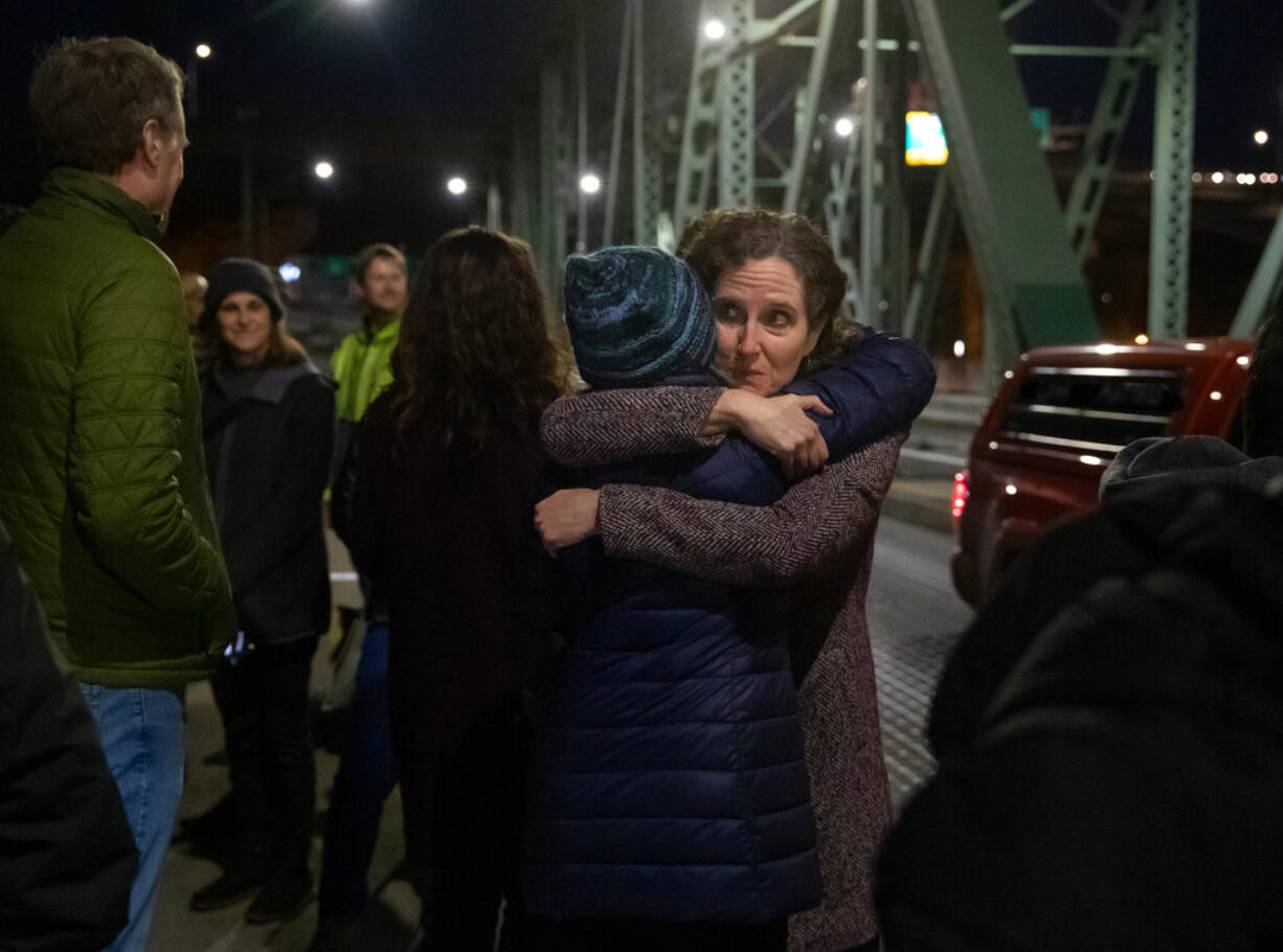 In a photo provided by Multnomah County, Dr. Jennifer Vines, lead regional health officer for the Portland metro area, hugs a county employee after moment of silence Thursday, March 10, 2022, in Portland, Ore., during an event marking two years since the first case of COVID-19 was confirmed in Portland.