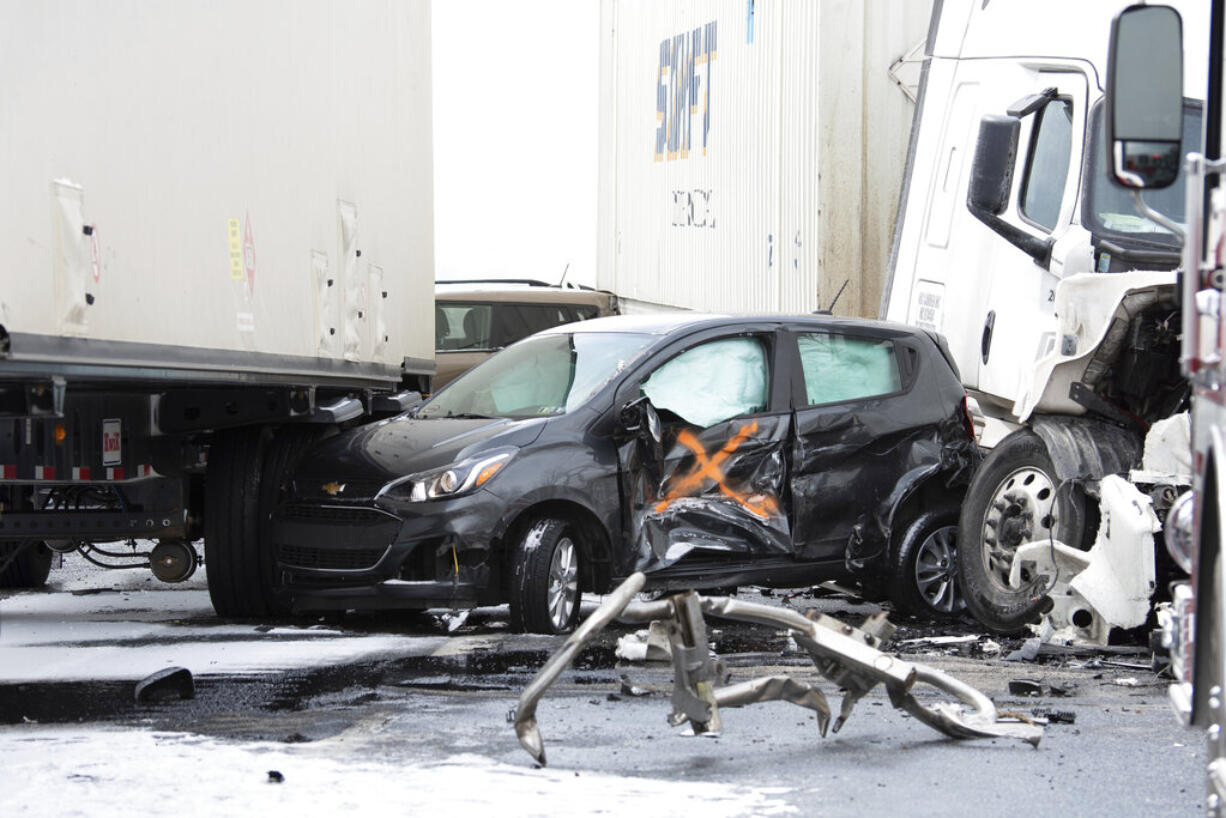 A small car is crushed between tractor trailers following a multi-vehicle crash on Interstate 81 North near the Minersville exit in Foster Township, Pa., Monday, March 28, 2022.