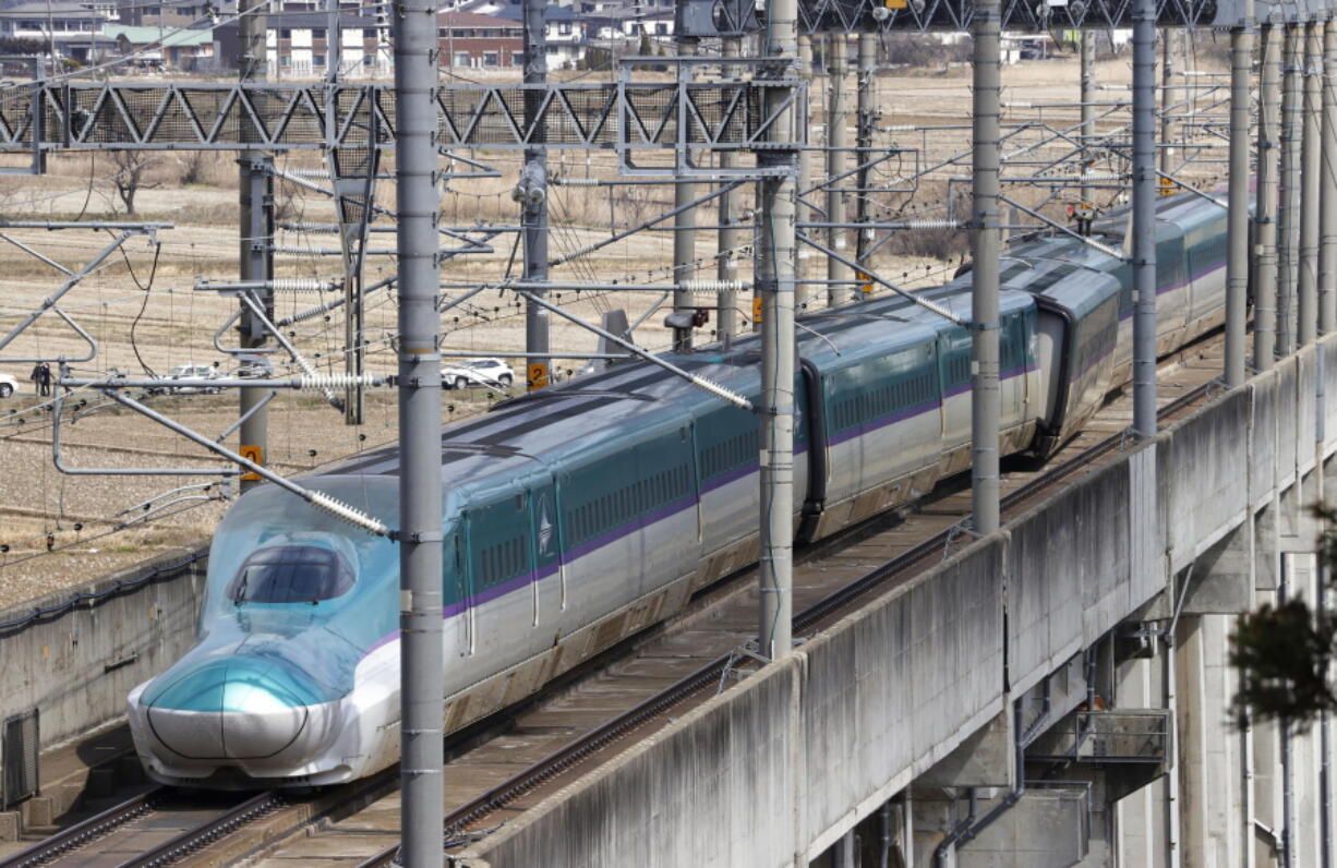 A partially derailed express train sits following an earthquake in Shiroishi, Miyagi prefecture, northern Japan Thursday, March 17, 2022. A powerful earthquake struck off the coast of Fukushima in northern Japan on Wednesday night, smashing furniture, knocking out power and killing some people. A small tsunami reached shore, but the low-risk advisory was lifted by Thursday morning.