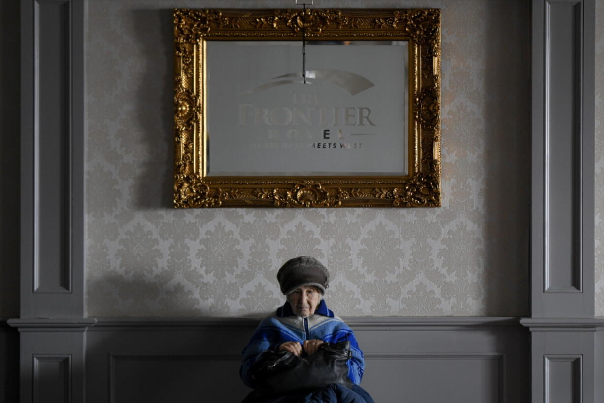 A refugee fleeing the conflict from neighbouring Ukraine sits in the banquet room of a hotel after crossing the border at the Romanian-Ukrainian border, in Siret, Romania, Thursday, March 10, 2022.